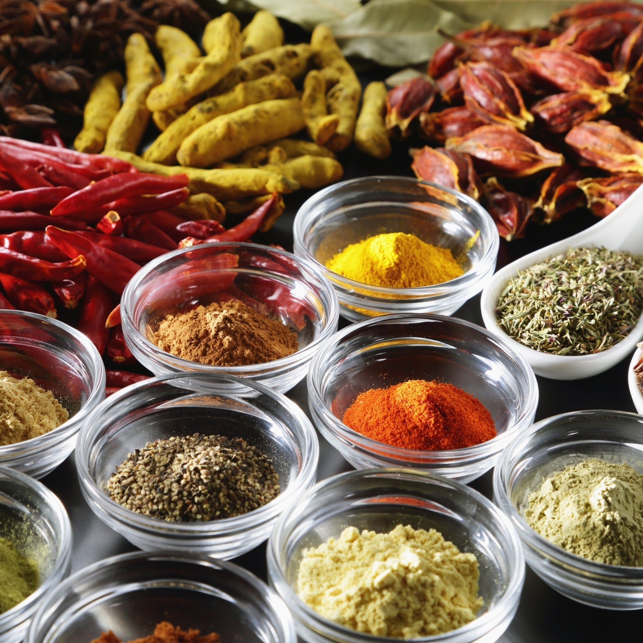 Different types of ground spices in bowls used for seasoning food.